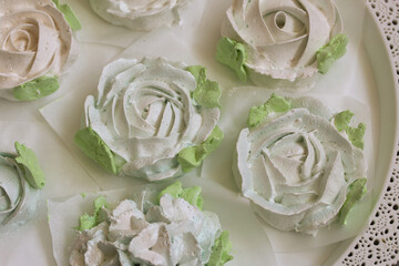 Homemade marshmallows of different shapes and colors. Zephyr flowers. On pine boards.