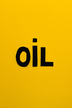 Top view of paper oil word on yellow background.