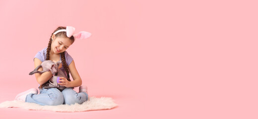 Little girl with bunny ears and cute Sphynx cat on pink background with space for text