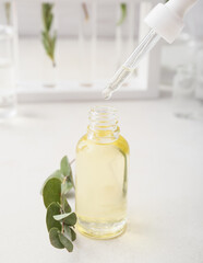Bottle of eucalyptus essential oil on table in laboratory