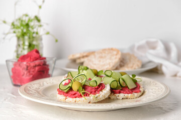 Plate with crispbreads and tasty hummus on table