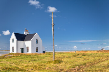 Fototapeta na wymiar Alone white house in the countryside of Scotland with sunny day, Scotland