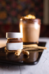 Coffee with a jar of chocolate paste and cookies on a black plate