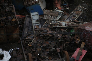 A pile of scrap metal in a warehouse in a wagon depot. Wheel sets, remains of trains