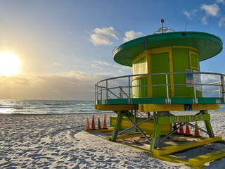 Iconic green lifeguard house in Miami Beach. Beautiful blue sky at sunrise.