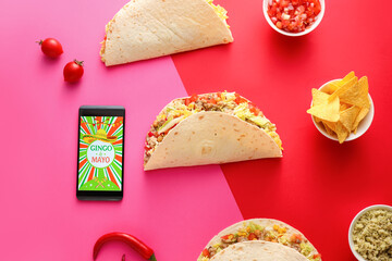 Traditional Mexican tacos and mobile phone on color background. Cinco de Mayo (Fifth of May)...