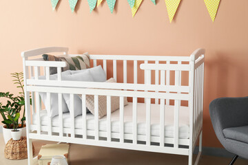 Stylish children's room with crib near color wall