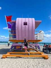 Brazilian woman in pink, in a purple lifeguard house, in Miami Beach