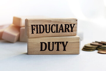 The inscription FIDUCIARY DUTY on wooden cubes isolated on a light background. Concept word forming on wooden cube. Business, economics and finance concept.