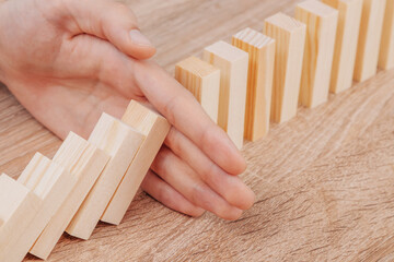 hand controlling domino effect pollution, business concept