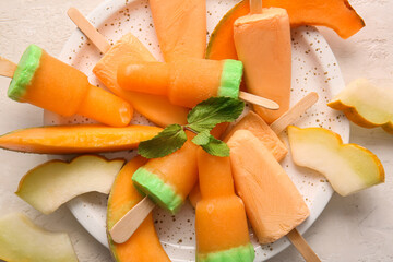 Plate with tasty melon popsicles on light background