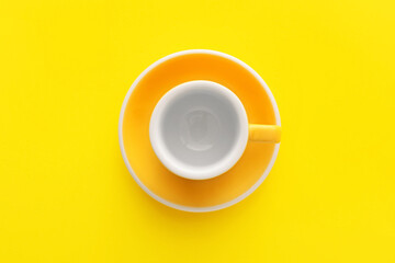 Stylish cup and plate on yellow background