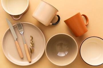 Set of stylish dinnerware on beige background