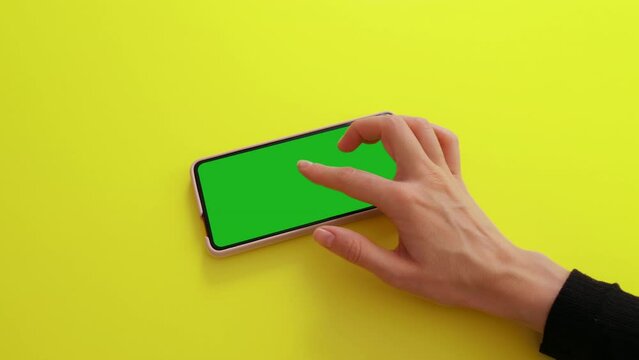 Gestures pack on Green Mock-up Screen Chroma Key phone. Female hand touching, zoom in, sliding, swiping, scrolling on smartphone screen in orizontal mode. Internet, communications concept.