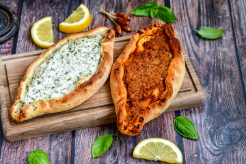 Traditional Turkish cuisine. Baked Pide dish with minced  beef, tomatoes and cheese on  wooden background.  Turkish pizza pide