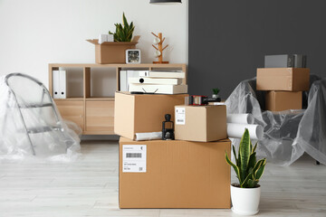 Cardboard boxes with belongings in interior of office on moving day