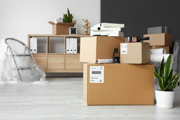 Cardboard boxes with belongings in office on moving day