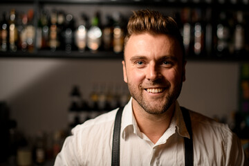 Portrait of young smiling man bartender with stylish hairstyle