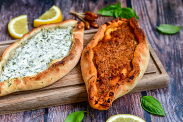  Traditional Turkish cuisine. Baked Pide dish with minced  beef, tomatoes and cheese on  wooden background.  Turkish pizza pide