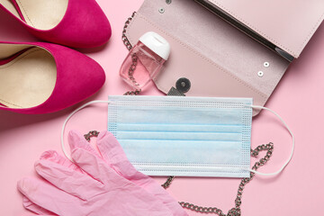 Stylish female accessories, medical mask, gloves and bottle with antiseptic on color background