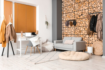 Interior of modern room with workplace, sofa and coat rack