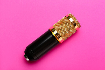 Modern microphone on pink background