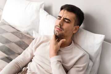 Ill young man with sore throat at home