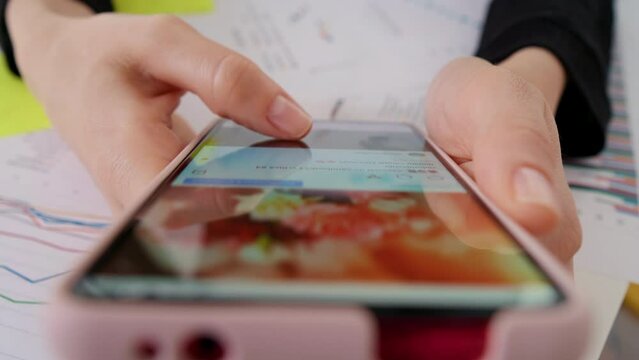 Person using smartphone, browsing through pictures on social network. Close-up Macro. Finger scrolling social media app feed, information search.