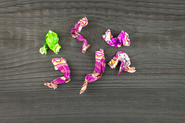 Candy wrappers on a black table background. Trash.