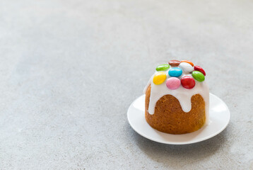 Holiday dessert. Easter cake with powdered sugar, decorated with colorful candy dragees. Light grey...