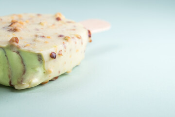 Pistachio ice cream with pistachio bits on blue background 