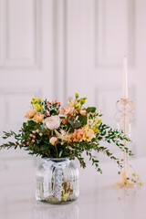 schöne Blumen Dekoration in einer Blumenvase vor weissem Hintergrund auf einer Hochzeit