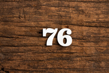 Number 76 - piece on rustic wood background