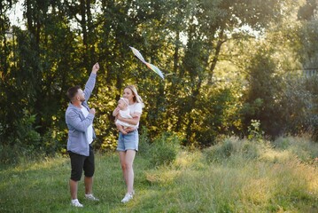 Obraz premium Happy young family spending time together outside in green nature.