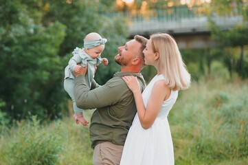 Happy young family spending time together outside in green nature.