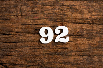 Number 92 - piece on rustic wood background - obrazy, fototapety, plakaty