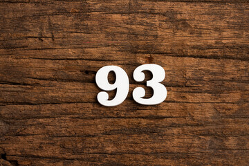 Number 93 in wood, isolated on rustic background