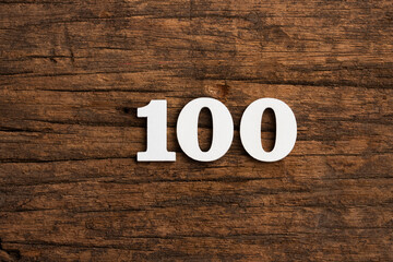 Number 100 - piece on rustic wood background