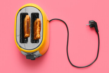 Modern toaster with bread slices on pink background