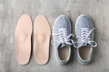 Shoes and orthopedic insoles on grunge background