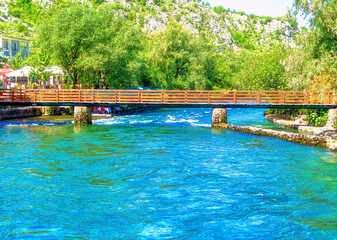 People walking over bridge at Buna river in Blagaj, Bosnia and Herzegovina.