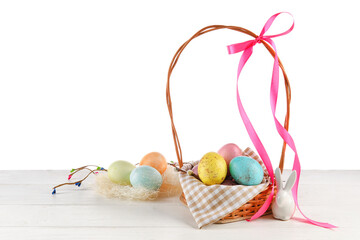 Basket of painted Easter eggs on table against white background