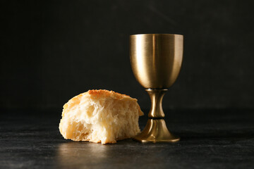 Cup of wine with bread on dark background