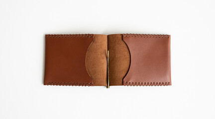 Open orange men's money clip handmade leather wallet. Empty money clip wallet with a two pockets for cards lies on a white table. Selective focus, copy space.