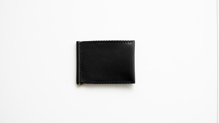 Black men's money clip handmade leather wallet. Empty money clip wallet with a two pockets for cards lies on a white table. Selective focus, copy space.