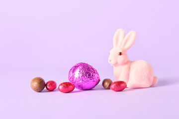 Chocolate Easter eggs and bunny on lilac background