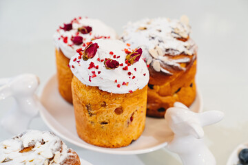 decorated panettones and cruffins on serving plate with rabbits. easter cakes. 