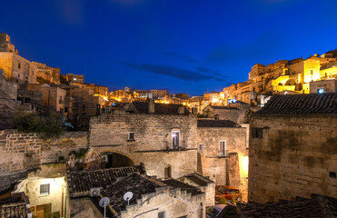 Fototapeta na wymiar Night view of the ancient city of Matera Italy including the ancient cave homes and outer wall in the Basilicata region of Matera, Italy. 