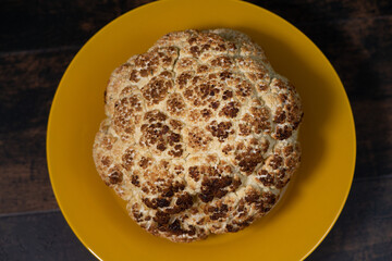 Roasted cauliflower in a yellow plate, turning