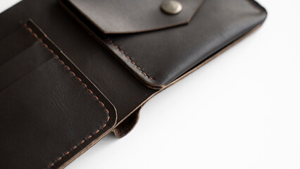 Top view of open brown empty man's black handmade genuine leather wallet with pockets for banknotes, credit cards and monets isolated on white background. Selective focus, copy space, Close up.